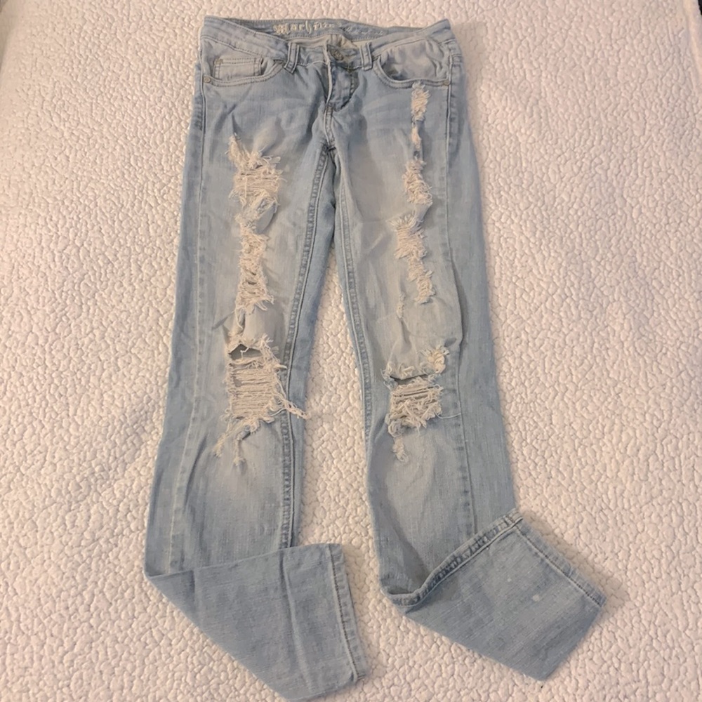 Blue straight jeans with ripped designs on the front and back pockets.
